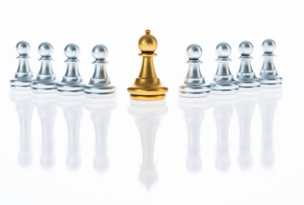 istock Golden and silver pawns in a white background 957393844