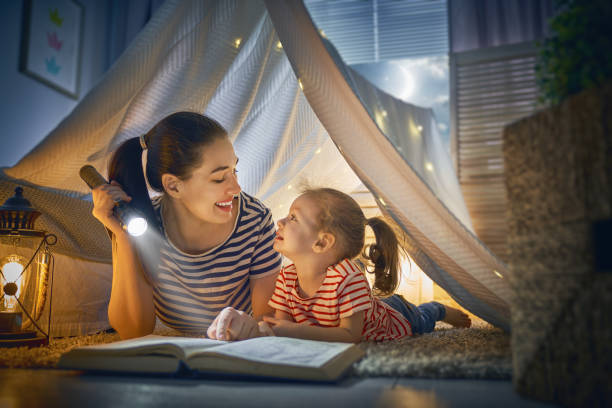 istock Mom and child reading a book 957394176