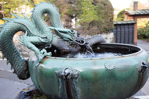 Nikko, Japan - April 14, 2016 : Old traditional Japanese dragon fountain in buddhist shrine at Nikko, Japan on April 14, 2016