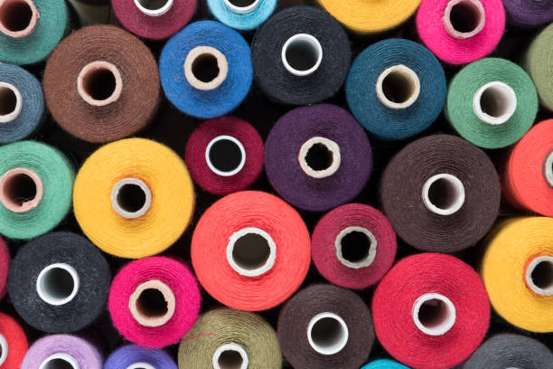 istock Stacked colored sewing threads, textile background and colourful wallpaper 957398614