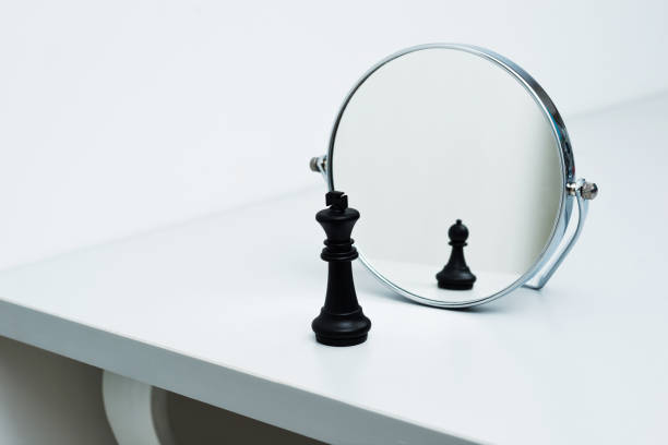 istock Black chess king imagining itself as a pawn 957407186