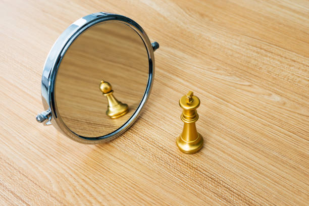 istock Golden chess king imagining itself as a pawn 957407188