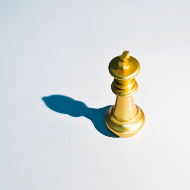 istock Golden chess king with the shadow of a pawn 957407828