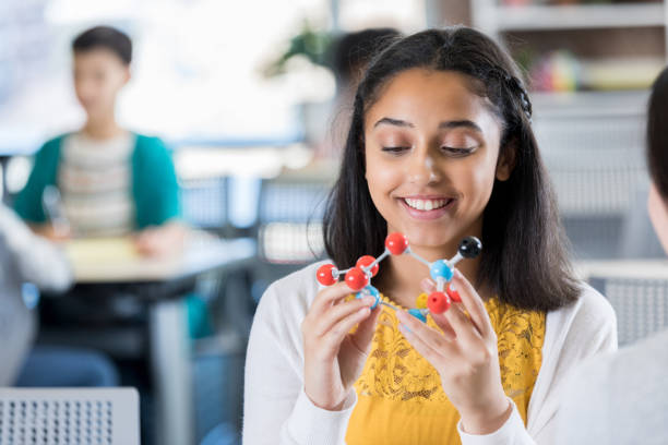 istock Confident teenage girl studies molecular structure 957407928
