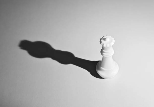 istock White chess queen with the shadow of a king 957407948
