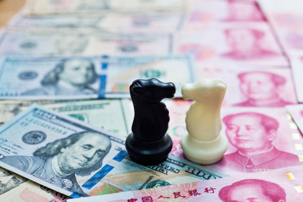 istock Chess knights standing on dollar and China yuan 957415098