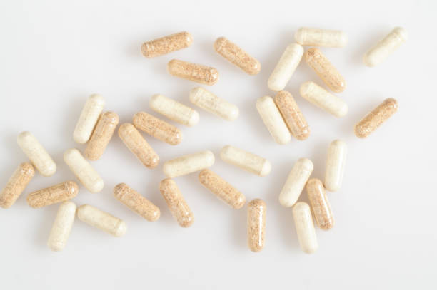 istock Medicine capsules are scattered on a white surface 957415624