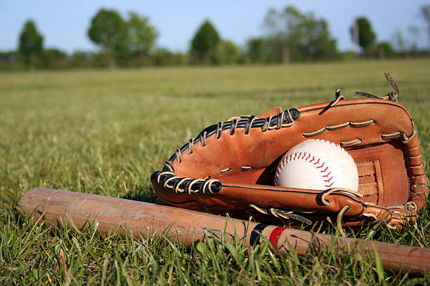 istock Baseball bat, mitt and glove lying in grass on a field 95742162