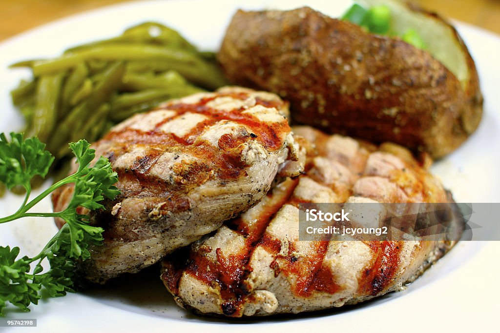 Chuleta de cerdo con deliciosa comida con papas al horno - Foto de stock de Al horno libre de derechos