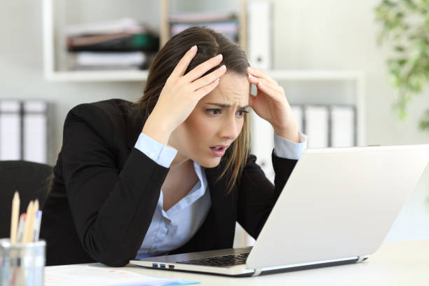 Worried executive receiving bad news on line at office Worried executive complaining receiving bad news on line in a laptop at office melancholy computer support specialist stock pictures, royalty-free photos & images
