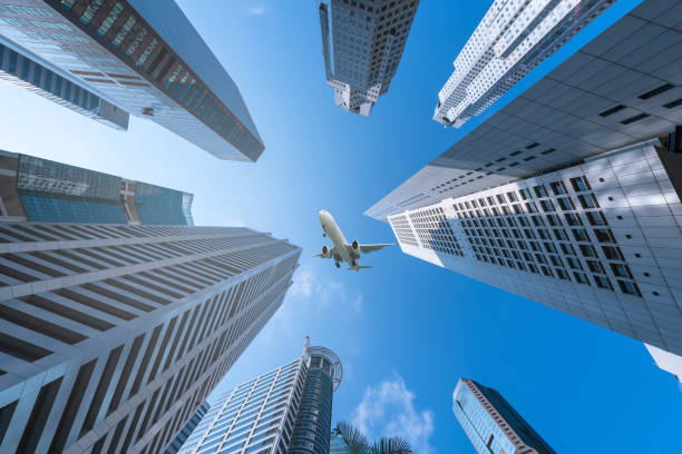 istock Plane flying over city on blue sky background. 957431262
