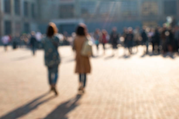 istock Blurred background with two women walking in the street. 957431978