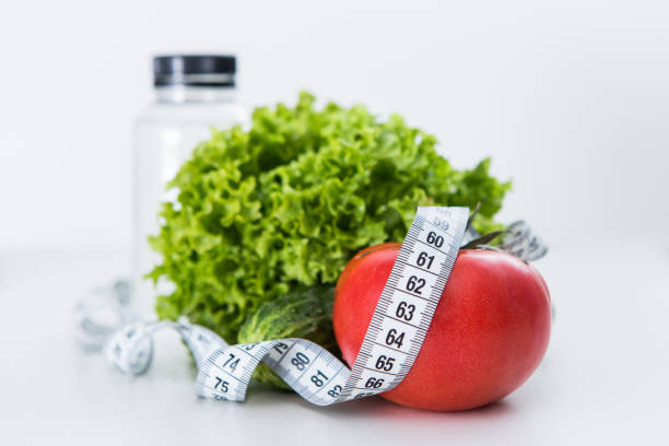 istock Dieting, tape measure with vegetables and water 957432726