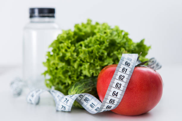 istock Dieting, tape measure with vegetables and water 957432832