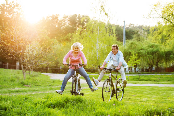 piękna para seniorów z rowerami na zewnątrz w wiosennej przyrodzie. - senior adult outdoors physical activity mode of transport zdjęcia i obrazy z banku zdjęć