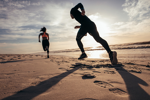 Fit people sprinting on the beach