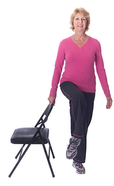 Senior woman balancing on one leg stock photo