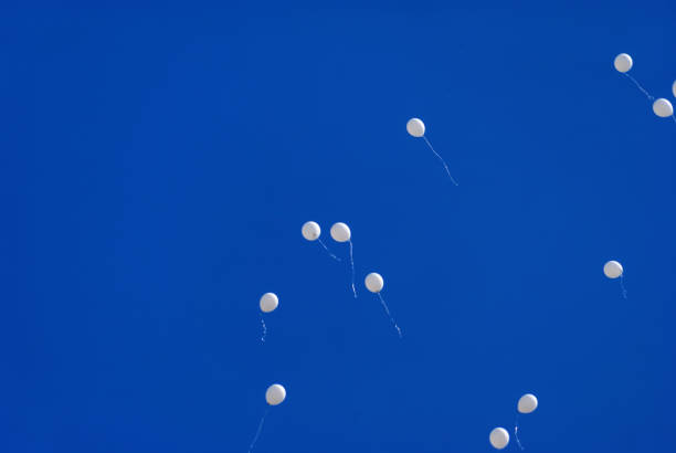 istock White balloons in the blue clear sky 957465164
