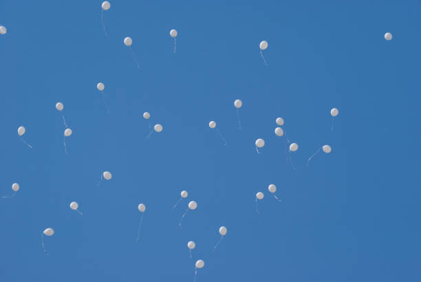 istock White balloons in the blue clear sky 957465216