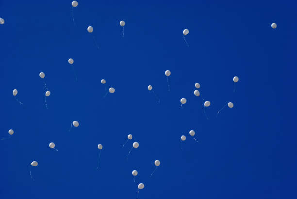 istock White balloons in the blue clear sky 957465260