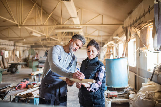 istock Man and woman workers in the carpentry workshop. 957473638