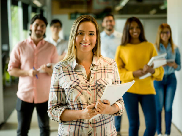 istock Woman at a creative office with a group at the background 957477108