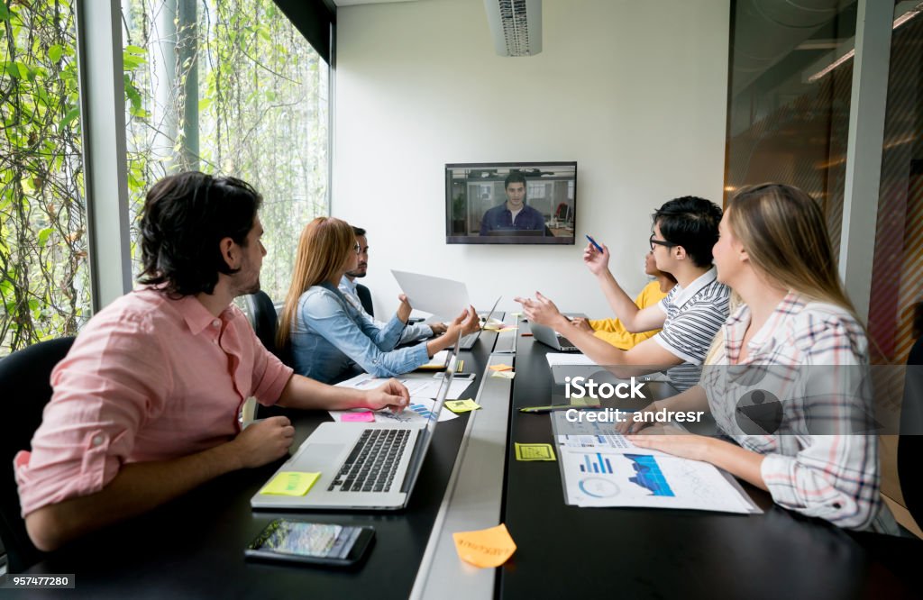 Groupe de personnes à une réunion dans un bureau créatif de faire une vidéo-conférence - Photo de VoIP libre de droits