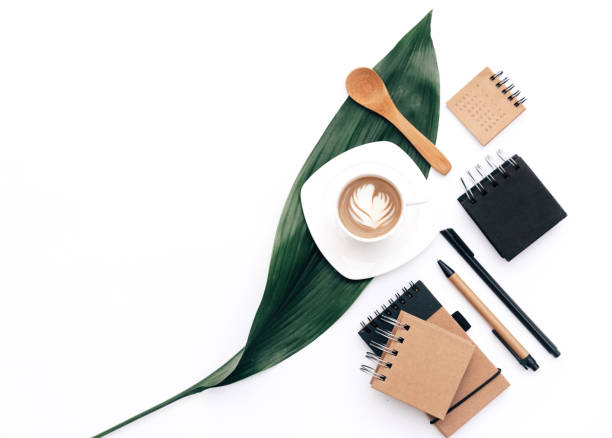 istock Flat lay Modern blogger concept. Workspace with eco Kraft items coffee and green leaf on white background. Home office desk. 957482406
