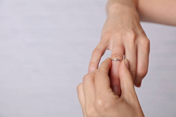 istock Swollen Hands. Woman trying to put on her wedding ring 957482740