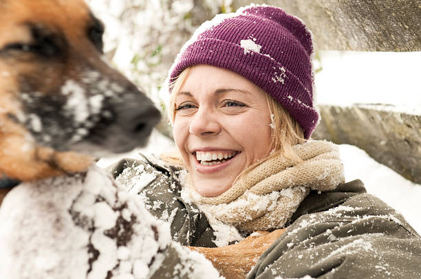 istock Young Woman Playing in the Snow With a Dog 95749627
