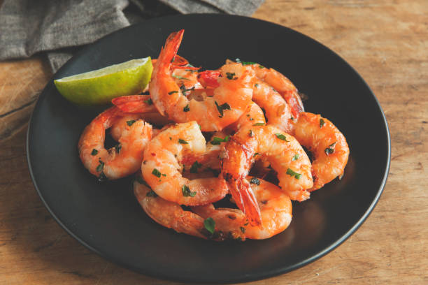 istock fried roasted shrimps in plate with lemon greens parsley garlic 957504696