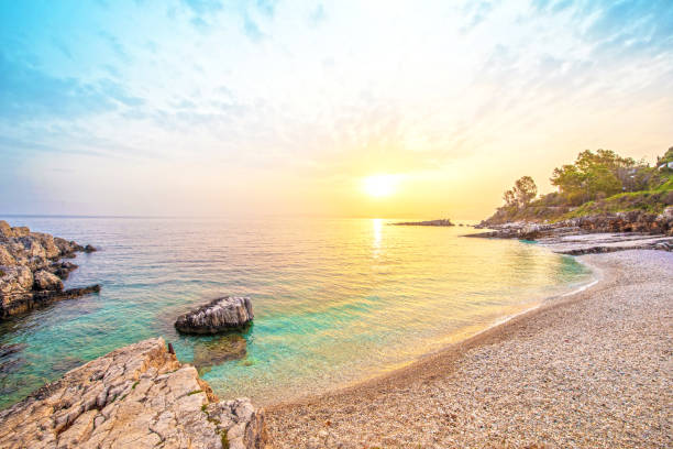 wspaniały piękny magiczny krajobraz z kamieniem o świcie na plaży bataria na wybrzeżu morza ijańskiego na korfu (керкіра), grecja. niesamowite miejsca. atrakcje turystyczne. - corfu greece sea beach zdjęcia i obrazy z banku zdjęć