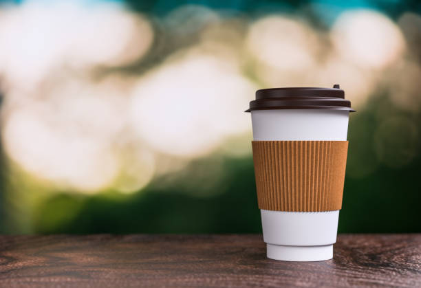 istock coffee takeaway on the table - bokeh background - 3d illustration rendering 957531034