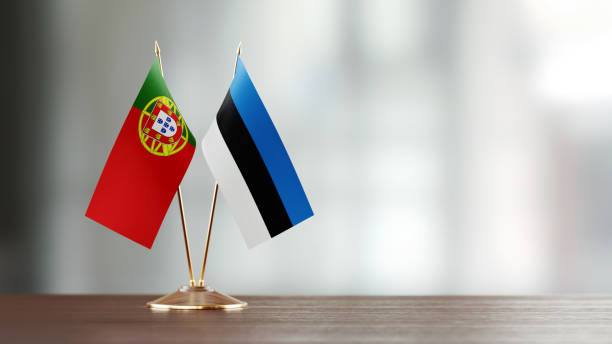 istock Portuguese And Estonian Flag Pair On A Desk Over Defocused Background 957540680