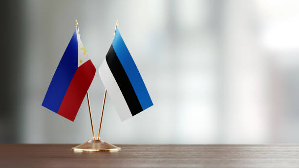 istock Philippines And Estonian Flag Pair On A Desk Over Defocused Background 957544380