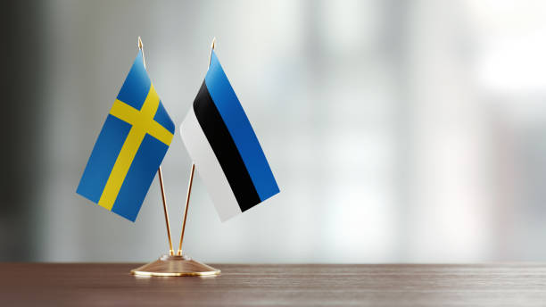 istock Swedish And Estonian Flag Pair On A Desk Over Defocused Background 957546610
