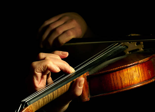 istock Musician playing violin isolated on black 95754944