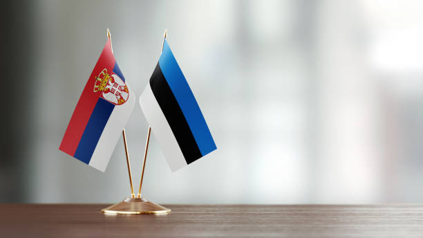 istock Serbian And Estonian Flag Pair On A Desk Over Defocused Background 957549894