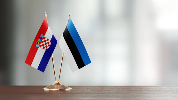 istock Croatian And Estonian Flag Pair On A Desk Over Defocused Background 957550112