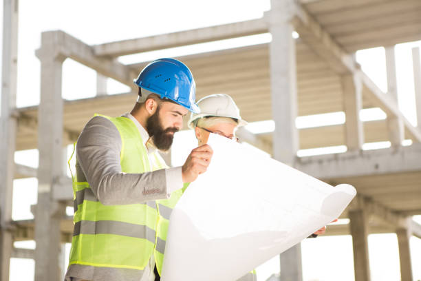 istock Hipster engineer and his colleagues on the construction site. 957550284