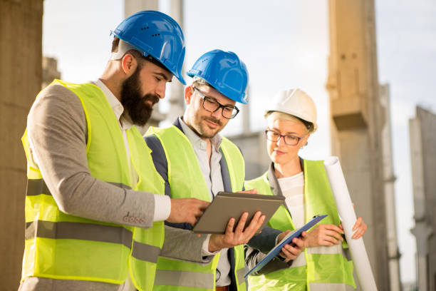 istock Hipster engineer and his colleagues on the construction site. 957550680