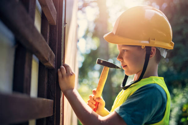 little manual worker hammering a nail - home improvement work tool hammer portrait imagens e fotografias de stock