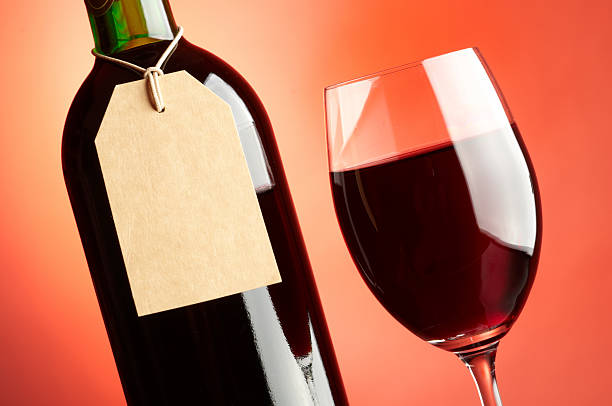 Glass and bottle of red wine with tag stock photo