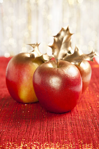 istock gilded apples and holly bush on glitter red backdrop 95756086