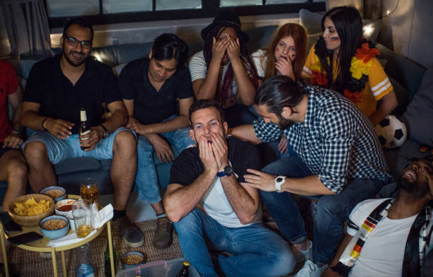 istock Soccer fans cheering at home 957566596