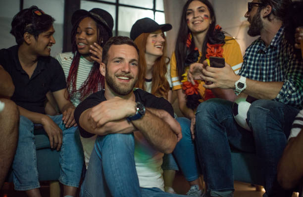 istock Soccer fans cheering at home 957566602