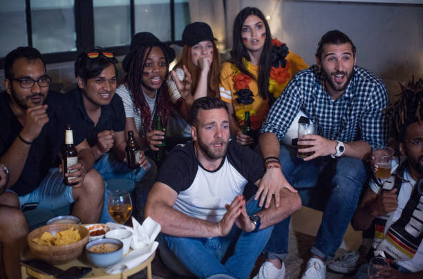 istock Soccer fans cheering at home 957567350