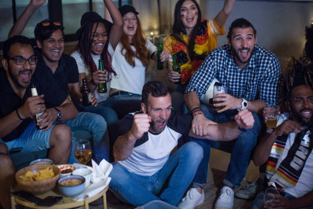 istock Soccer fans cheering at home 957567554