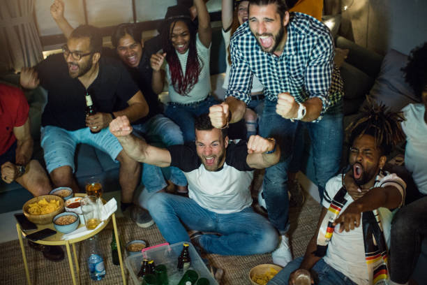 istock Soccer fans cheering at home 957570528