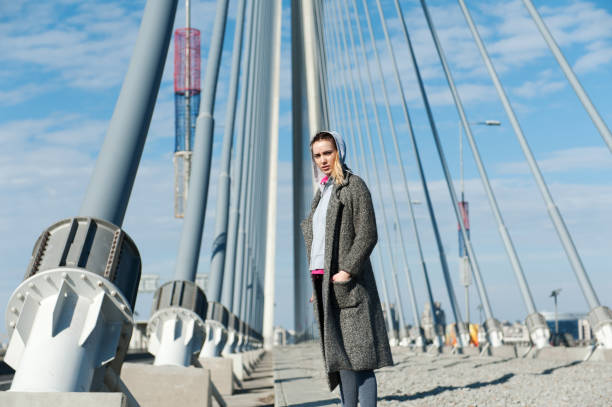 istock Beautiful young woman standing on the bridge 957571414